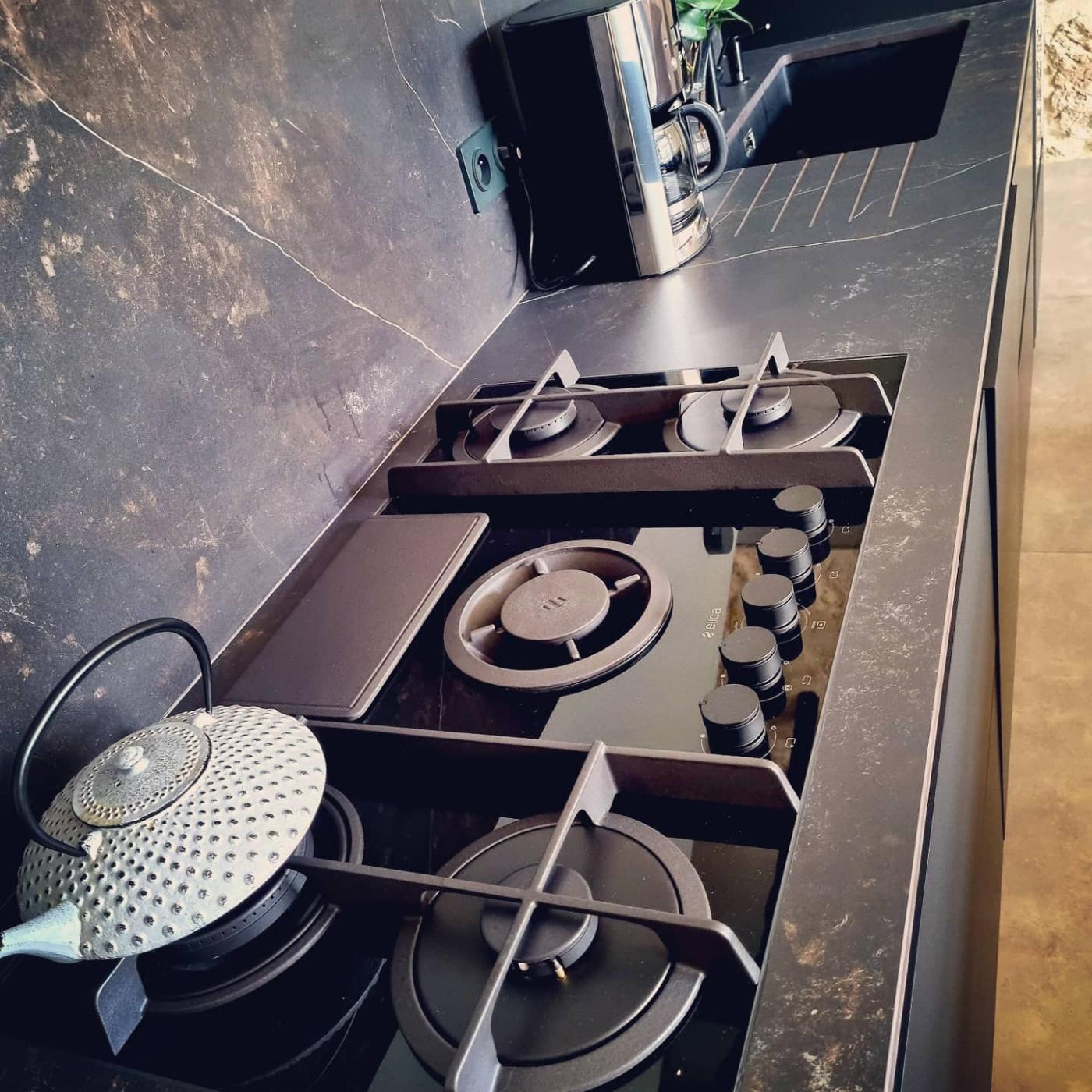 Spacieuse cuisine avec mur en pierres et poutres apparentes