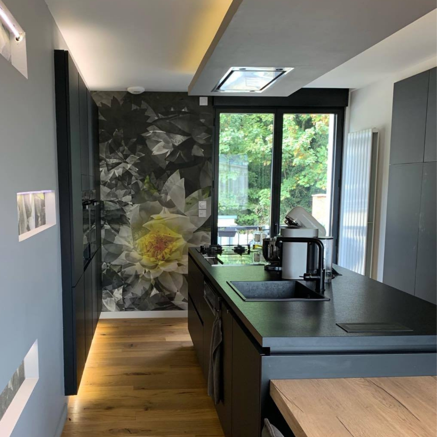 CUISINE MODERNE NOIRE AVEC ÎLOT CENTRAL ET PAPIER PEINT