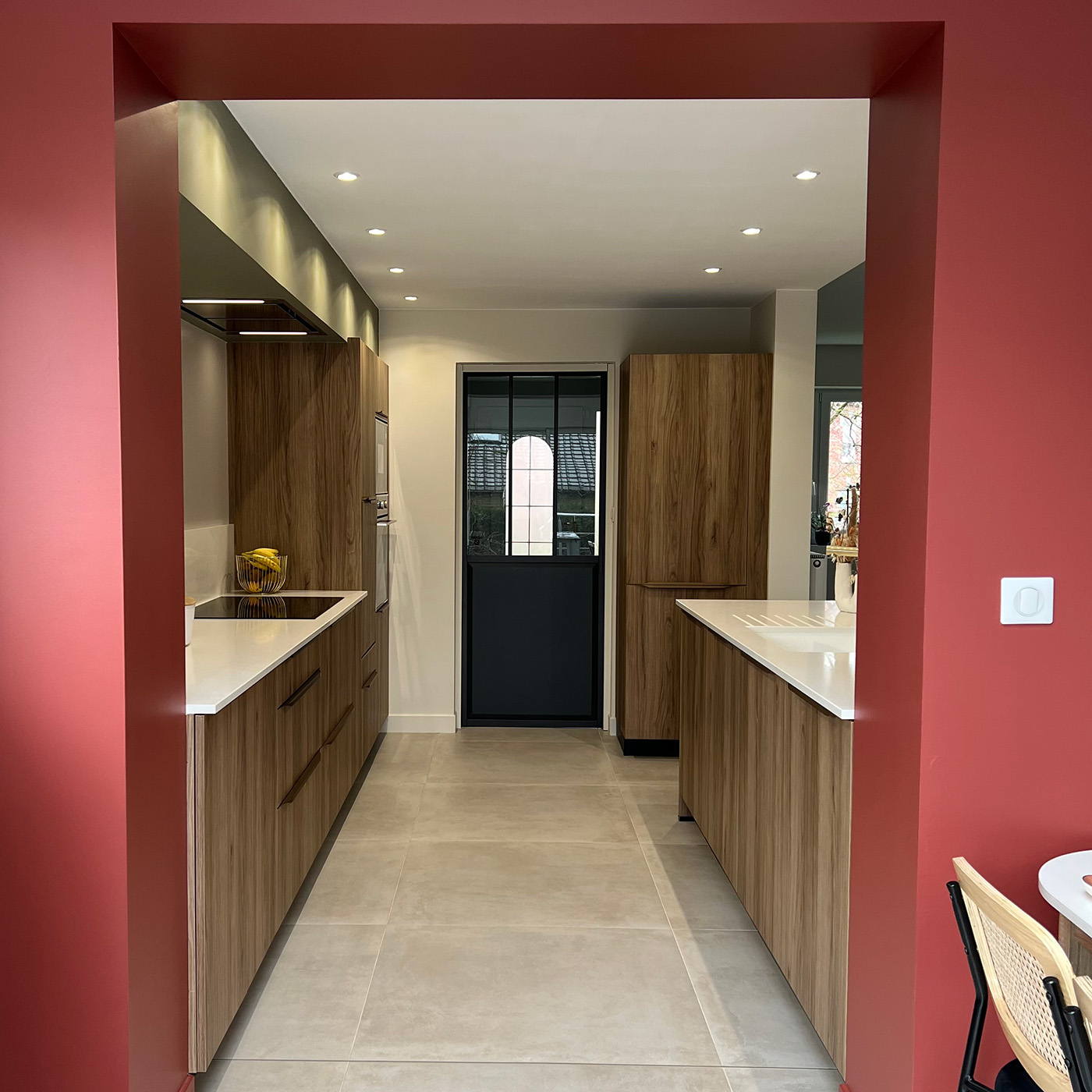 Cuisine raffinée blanche et bois avec mur terracotta